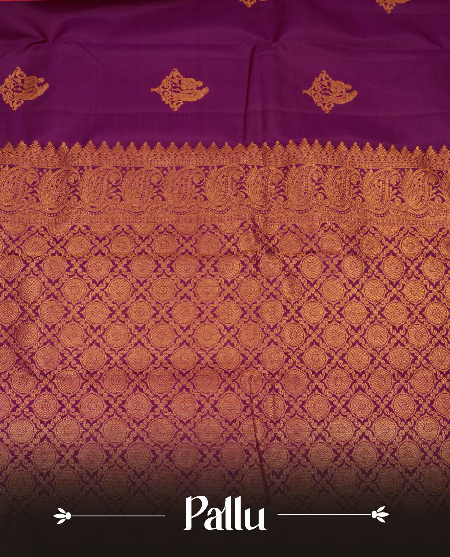 Rich magenta colour pure traditional Kancheepuram silk saree adorned with an elegant zari motif on the body, complemented by a grand gold zari woven border with intricate traditional patterns, paired with a matching blouse piece.