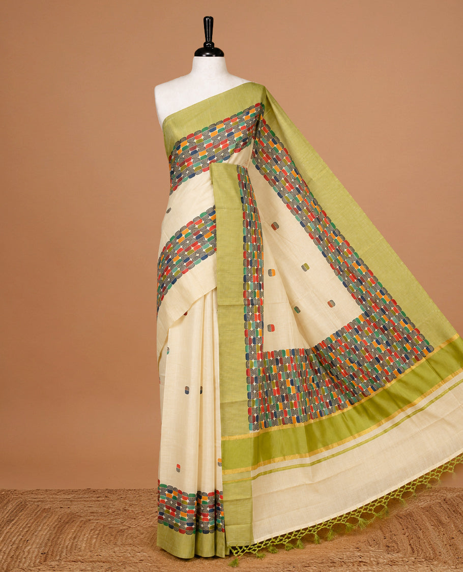 Cream Colour Tissue Kerala Saree Featuring A Classy Multicolour Box Pattern On The Body, Styled With A Green And Gold Zari Border And Pallu, Paired With A Matching Blouse Piece.