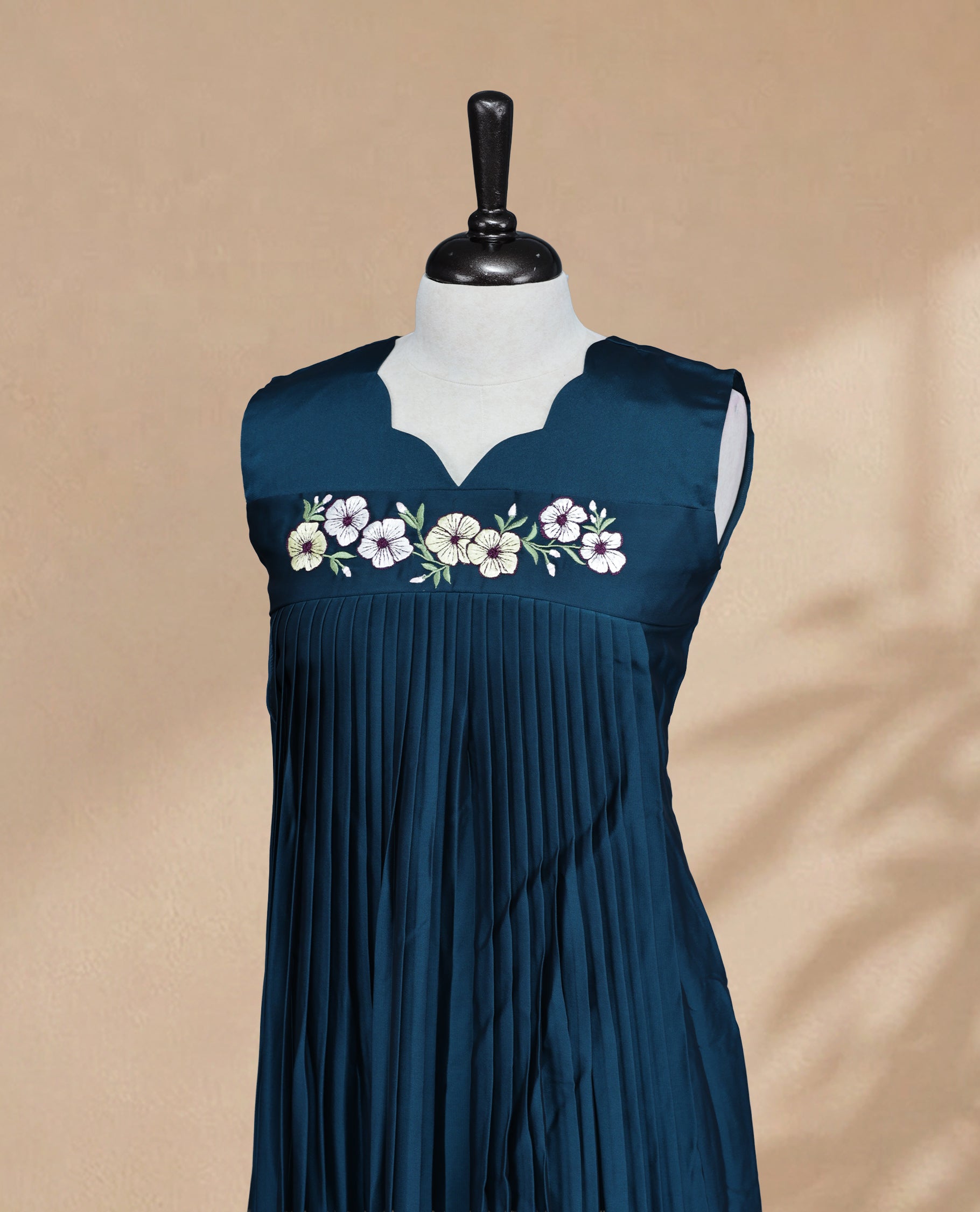 Teal Coloured Sleeveless Kurti Featuring a Designed Neckline, Floral Embroidery on the Body