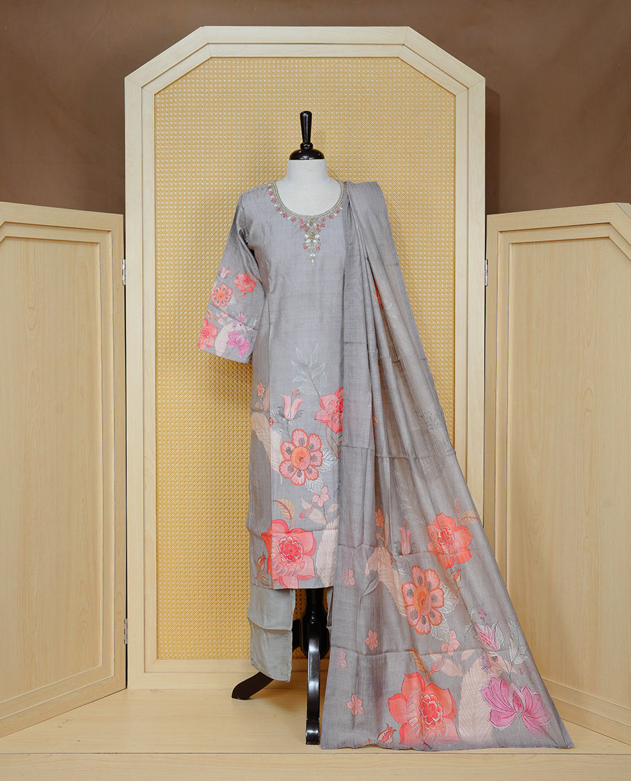 Grey colour churidar set featuring delicate floral prints on the body and intricate bead work on the neckline, paired with a matching floral printed dupatta and solid pants.