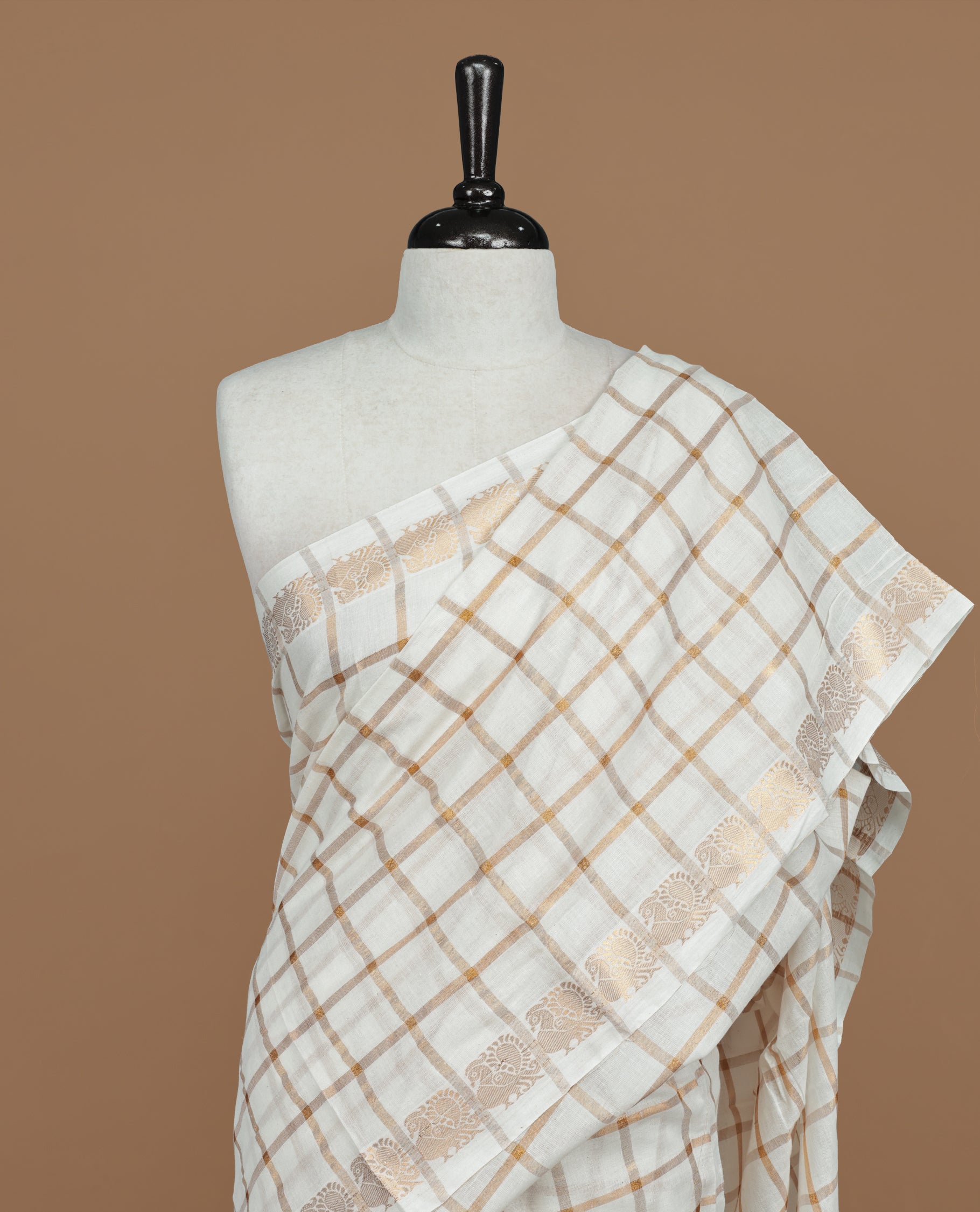Off white colour Sungudi cotton saree featuring Gold zari checks on body, Gold zari Peacock design on Self colour border, paired with matching blouse piece.