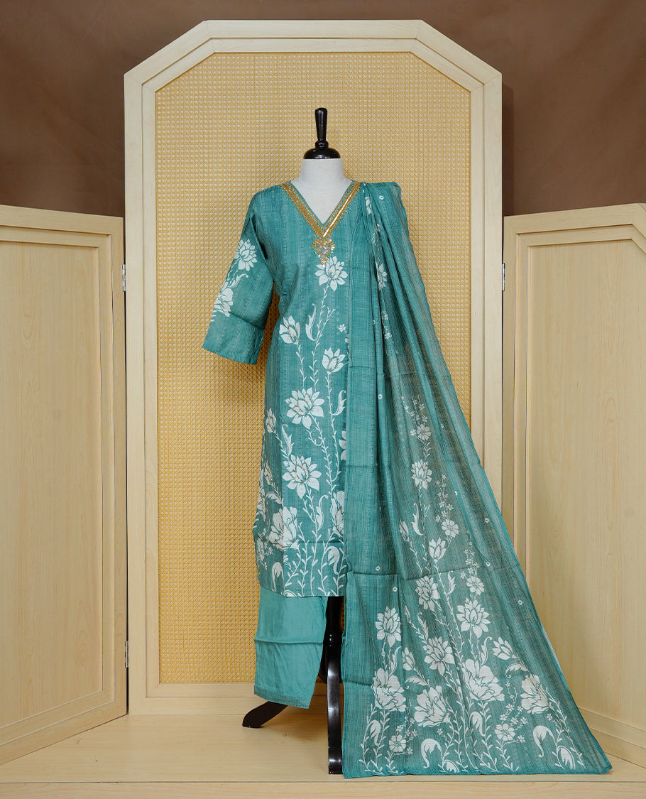Teal green colour churidar set with floral prints and mirror embellishments on the V-neckline, paired with a matching printed dupatta and solid pants.
