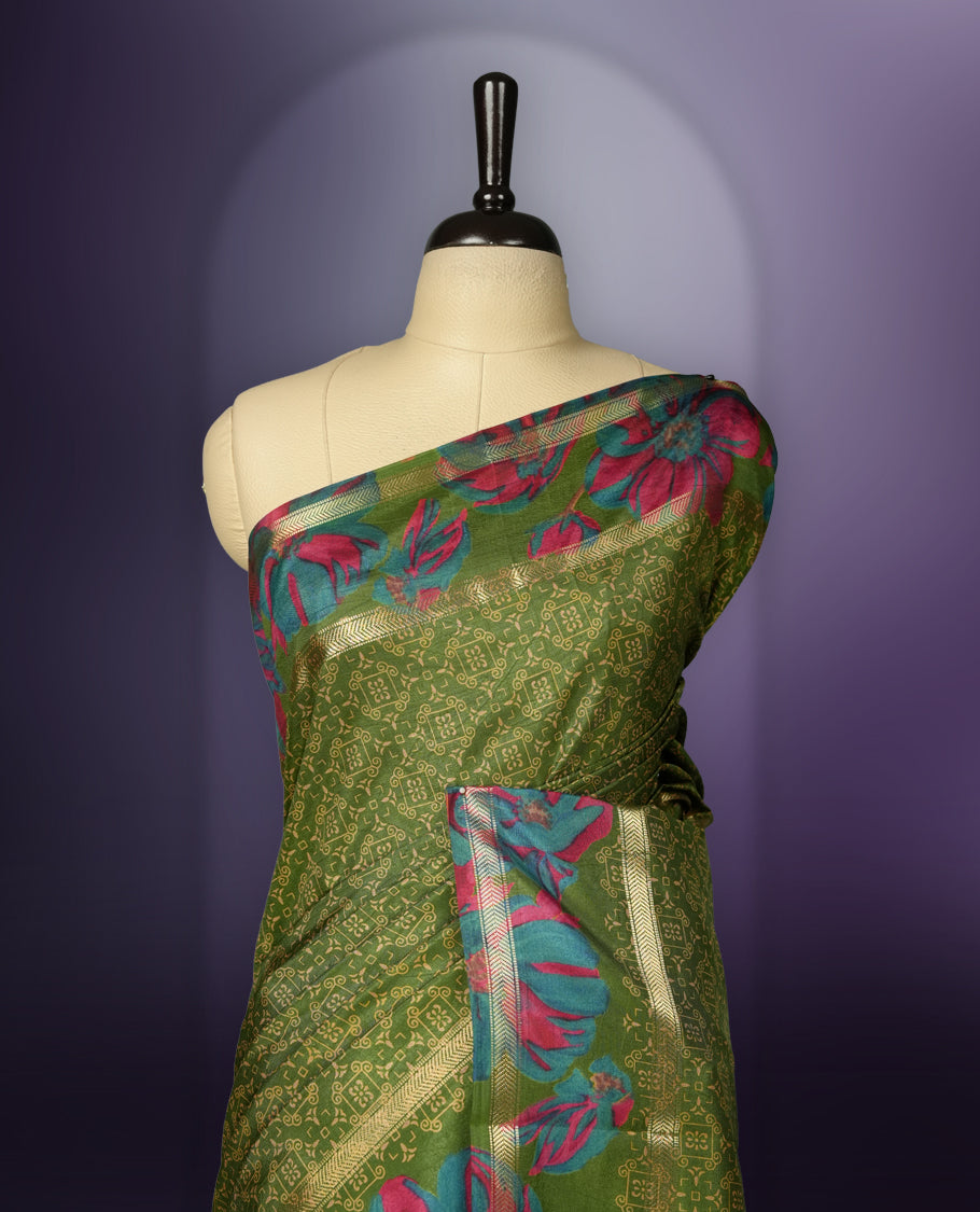 Green colour saree enhanced with a vibrant golden border and floral print pallu, adorned with intricate teal and pink floral prints on the body & comes with a matching blouse.