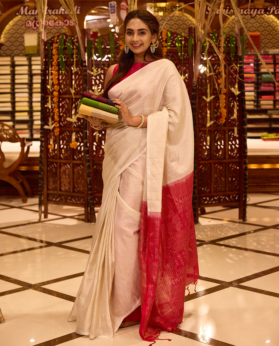 Elegant Ivory colour Kancheepuram silk saree enriched with a subtle sheen, gracefully contrasted by a bold Rani Pink pallu that adds a festive touch, styled with a matching blouse