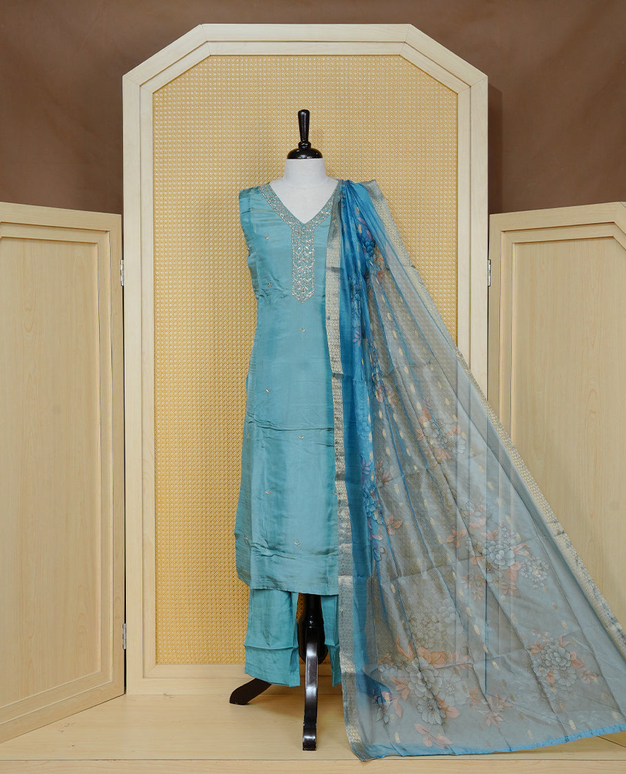 Sky Blue colour churidar set featuring delicate bead & stone Work on the V-neckline, paired with matching solid pants and a floral printed dupatta.