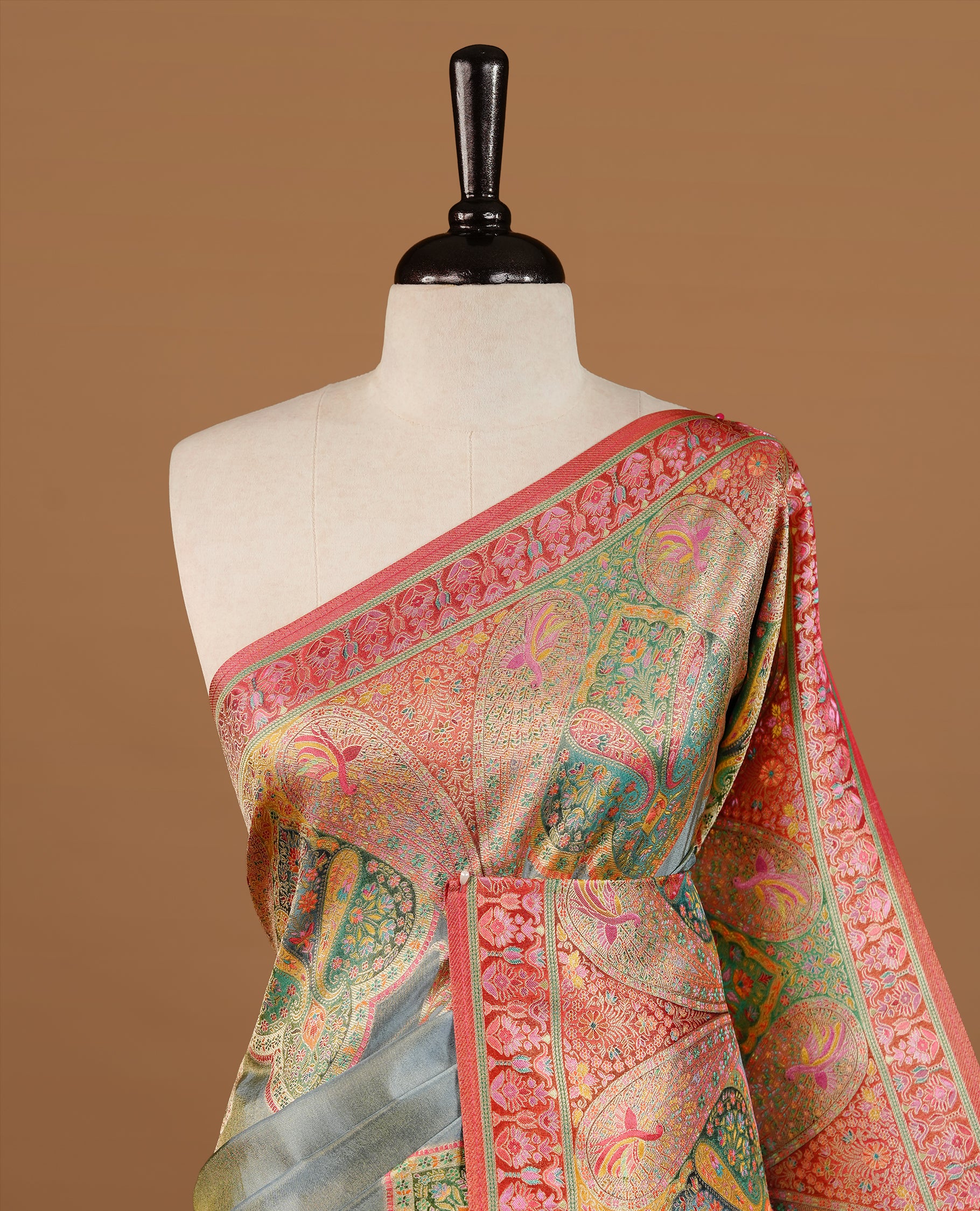 Grey colour Pashmina Saree featuring a plain lustrous body, a multicolour traditional woven border, a rich traditional woven pallu with intricate paisley motifs, paired with a matching grey blouse.