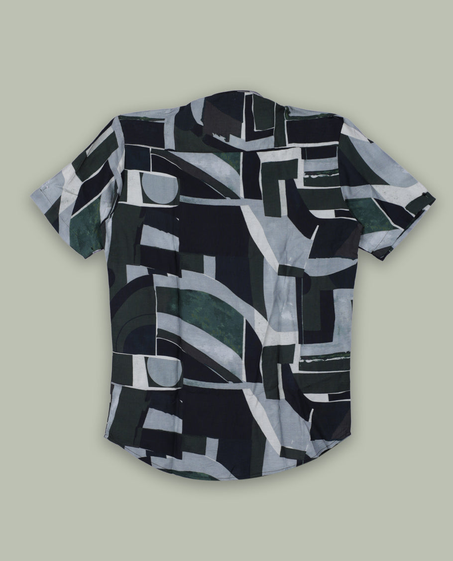 Dark green colour shirt featuring bold abstract geometric prints in shades of black, white, and grey & Designed with a classic collar and short sleeves, it offers a trendy, artistic look perfect for casual outings.