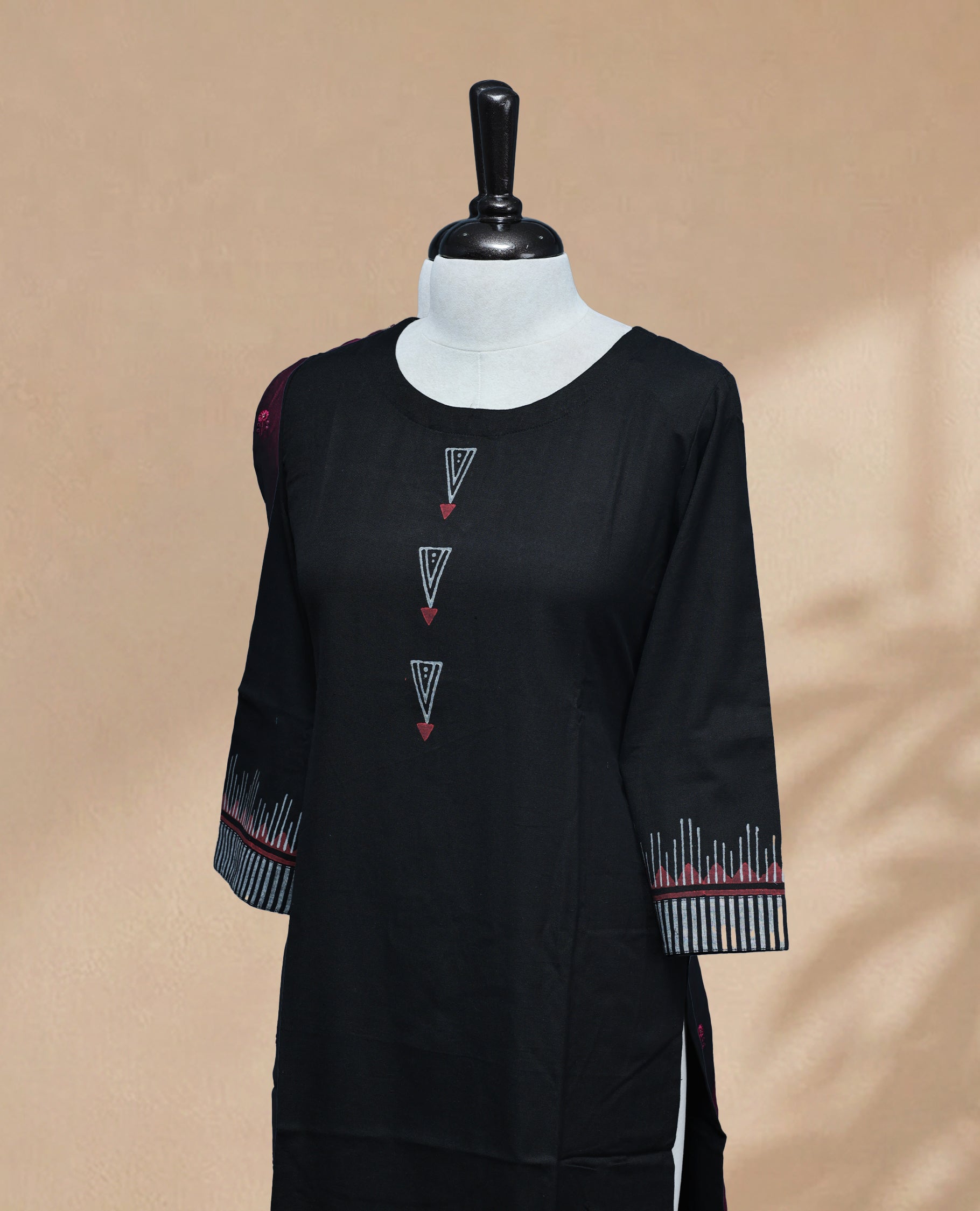 Black Kurti featuring vertical grey stripes on the bottom, a round neckline adorned with red and grey triangular detailing, and 3/4 sleeves with a matching design.