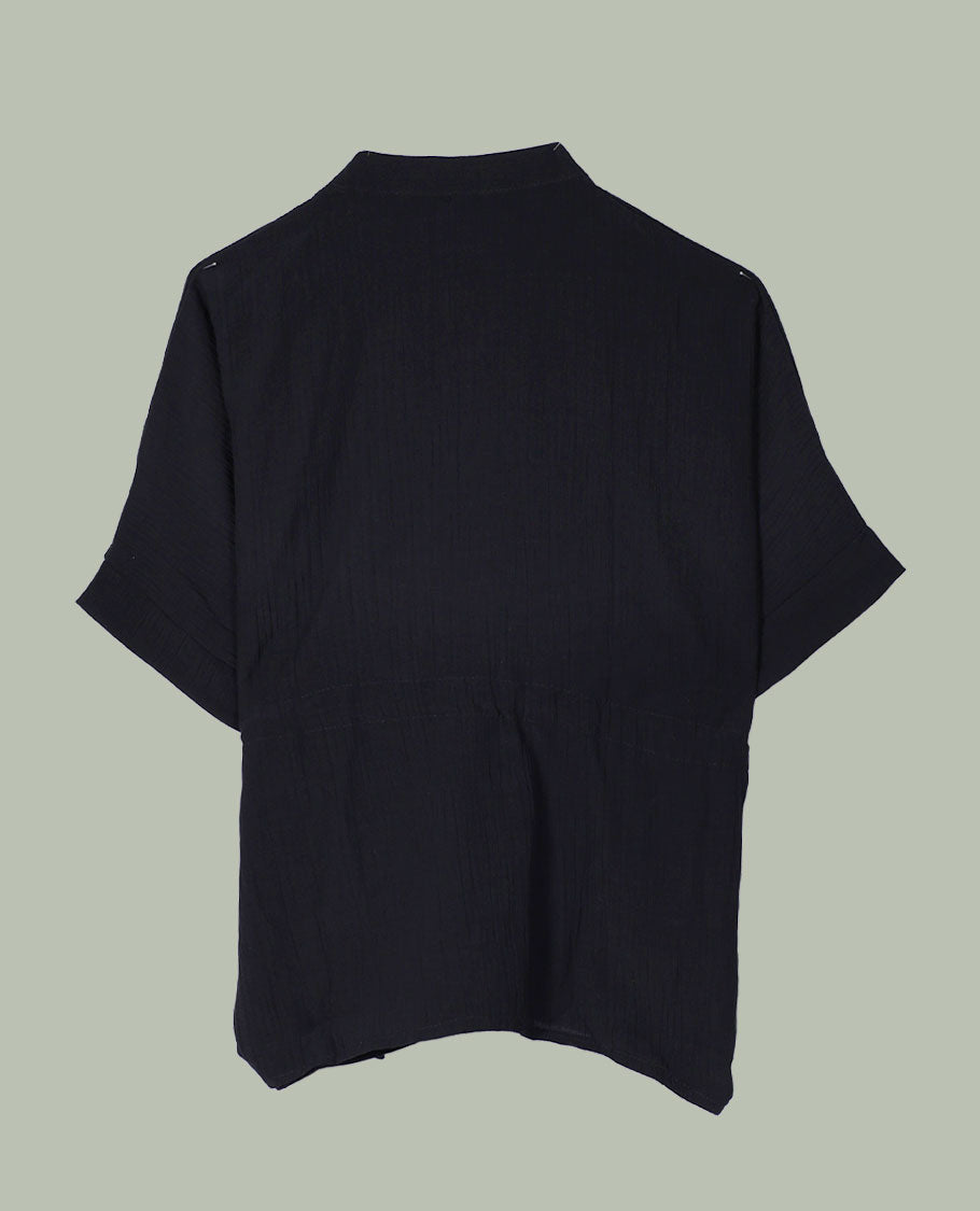 Black short-sleeve top with V-slit band neckline, contrast ivory crochet motif on one side, and adjustable drawstring detail at the waist.