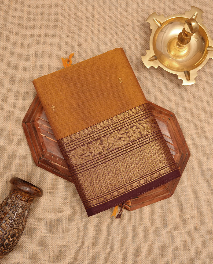 Mustard colour chettinad cotton saree featuring gold zari colour motifs on body, contrast purple colour border with gold zari border, pallu and paired with matching blouse.