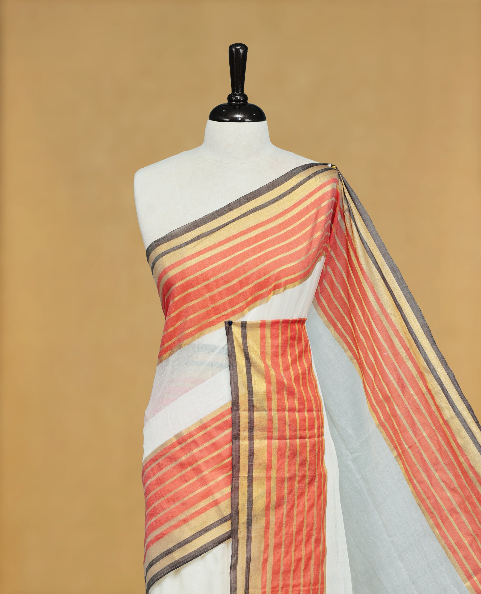 Off White Colour Mul Cotton Saree featuring Elegant Plain Body, Contrast Gold, Orange & black Border and Tassels Onam inspired charm.