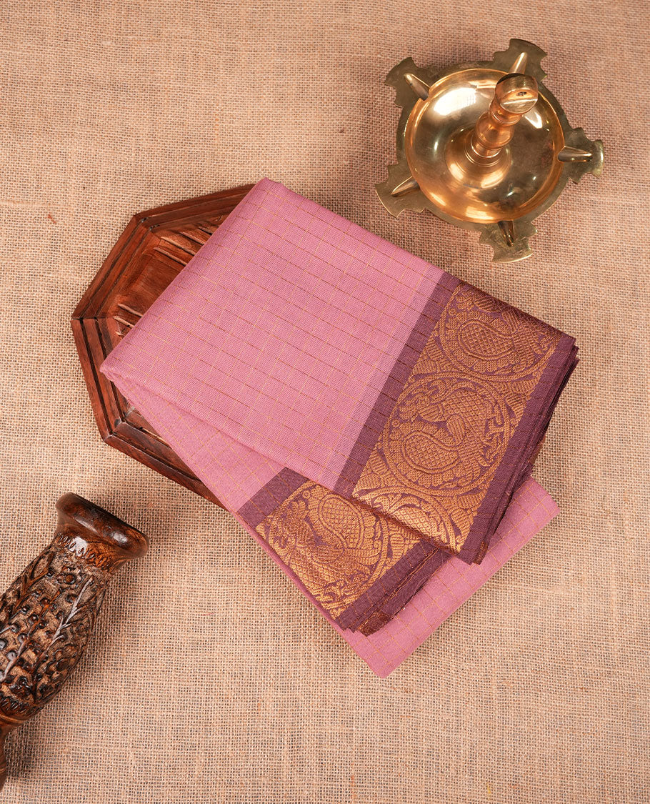 Light pink colour sungudi cotton saree featuring gold zari check pattern across body, contrast Mauve colour with gold zari peacock and floral pattern on border, without blouse piece.