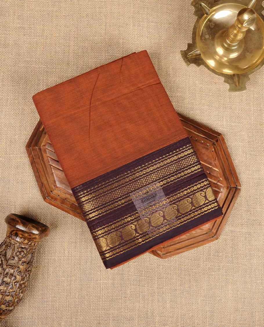 Brown colour chettinad cotton saree featuring plain body, contrast Deep purple colour with traditional gold zari border paired with matching blouse.