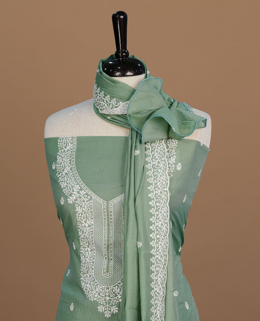 Pastel green colour churidar material feating white thread motifs on body and floral kodi pattern neckline, paired with matching bottom and dupatta.