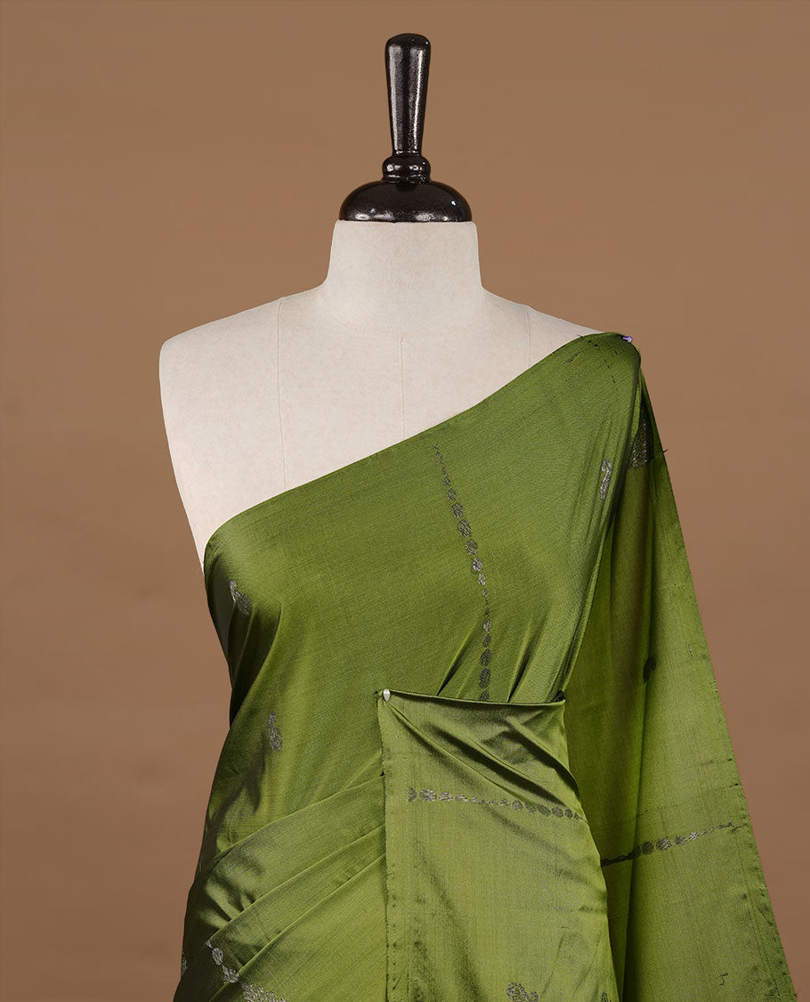 Olive colour soft silk saree features a sleek borderless design with intricate antique zari motifs, flowing into a striking contrast deep purple pallu and a matching blouse piece.