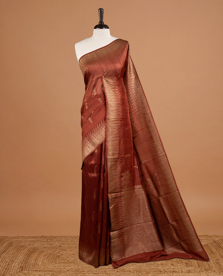 Brown colour Semi Banaras Tussar Georgette Featuring Gold zari Leaf pattern on body, Finished with Gold zari border and paired with matching blouse piece.