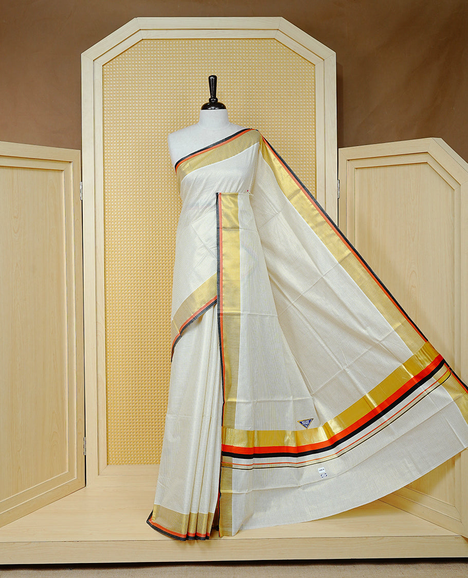 Cream colour cotton Kerala saree Featuring Gold zari Checks across the body, complemented by Classy gold zari with an orange & black Border & pallu, paired with a matching blouse piece.