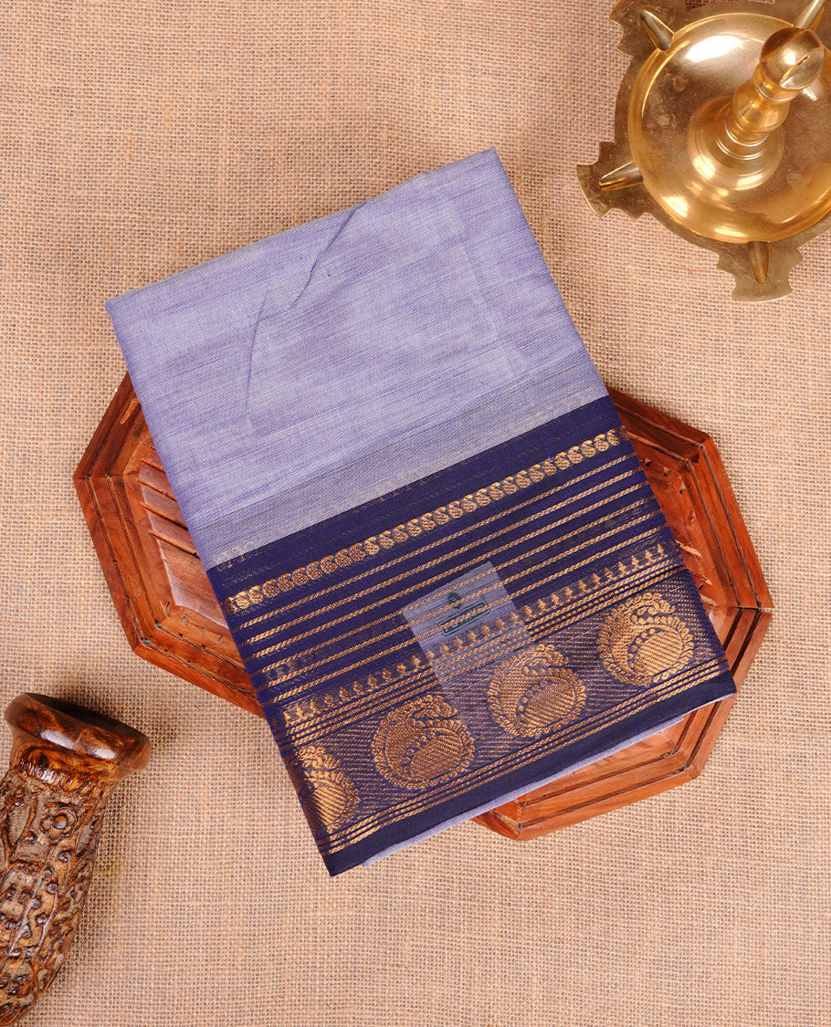Lavender colour chettinad cotton saree featuring plain body, contrast Dark blue colour with traditional gold zari border paired with matching blouse.