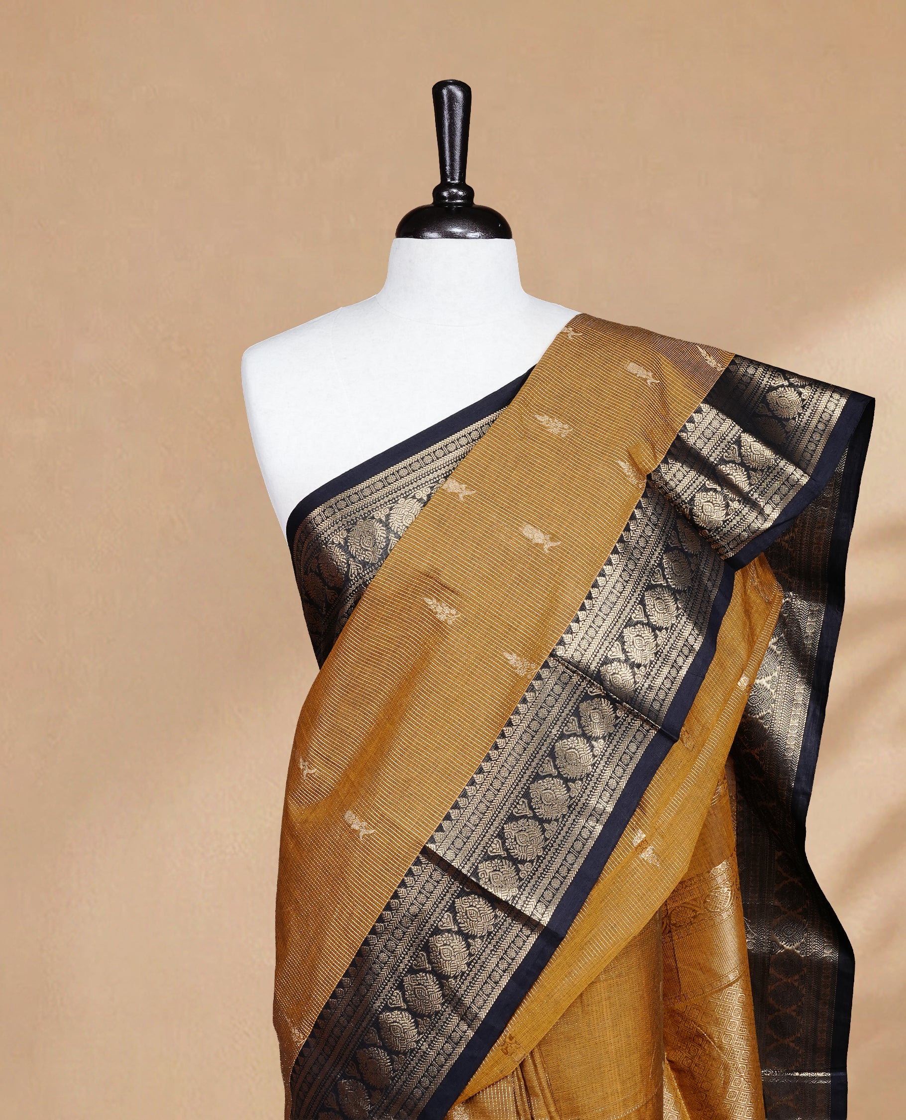 Mustard colour chettinad cotton saree featuring gold zari stripes & motifs on body, complemented by Contrast Black colour with zari border, paired with matching blouse piece.