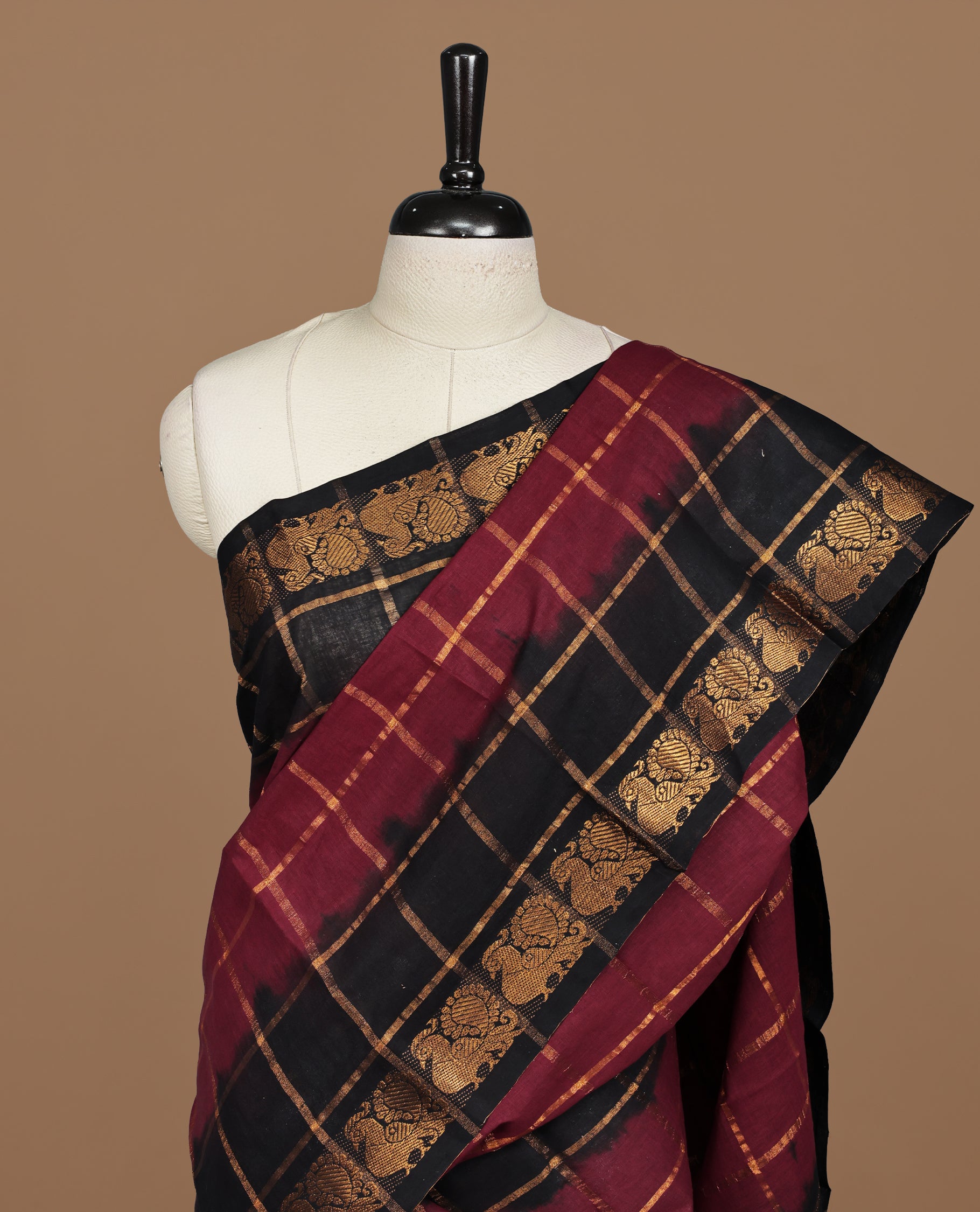 Maroon colour Sungudi cotton saree featuring Gold zari Check pattern on body, Gold zari Peacock design on Dyed Black colour design border, paired with matching blouse piece.
