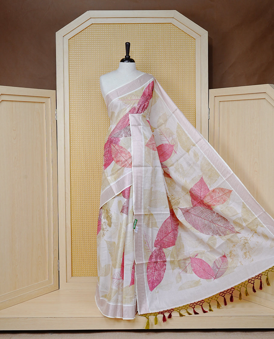 Cream Colour Tissue Kerala Saree Featuring A Digital Leaf Prints On Body & Pallu, Beautifully Enhanced With A Classic Rose Gold Zari Border And Olive Green & Maroon Tassels Paired With A Matching Blouse Piece.