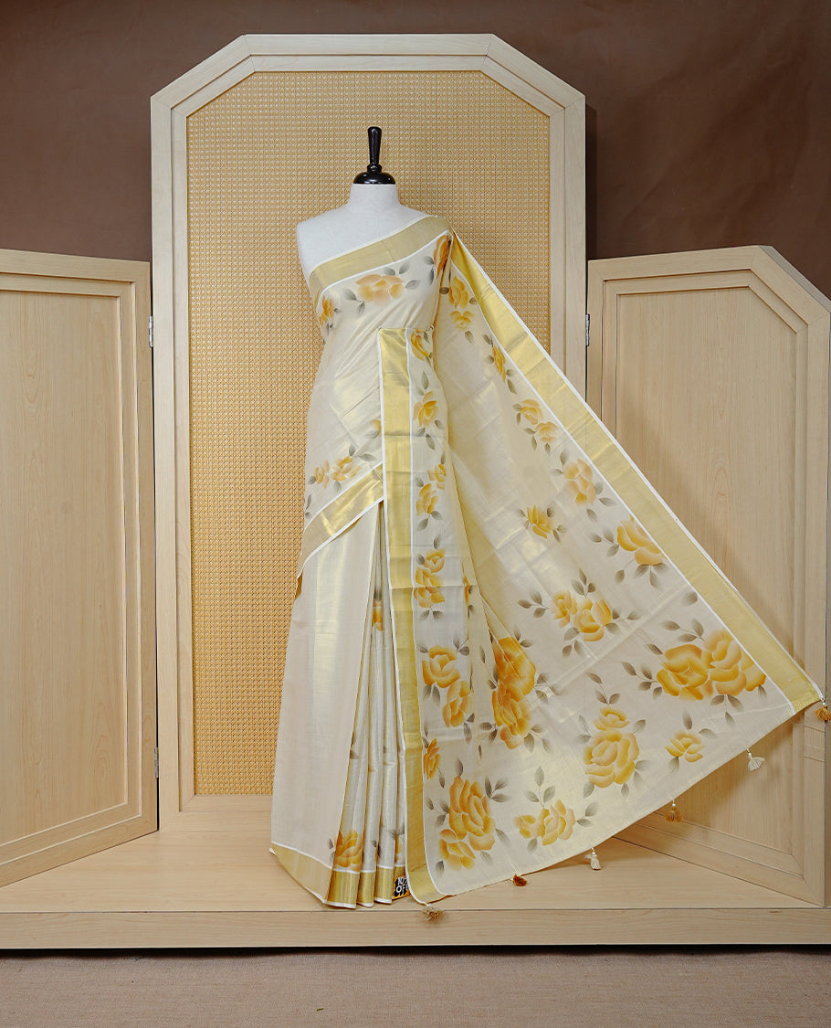 Cream Colour Tissue Kerala Saree Featuring Vibrant Floral Digital Printed Border & Pallu , Beautifully Enhanced With A Classic Gold Zari Border And Contrast Tassels. Paired With A Matching Blouse Piece.