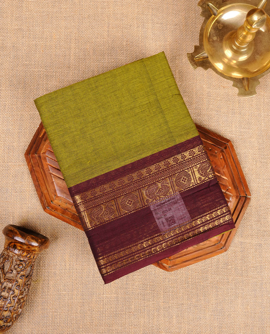 Olive colour chettinad cotton saree featuring plain body, contrast chocolate brown colour with traditional gold zari border paired with matching blouse.