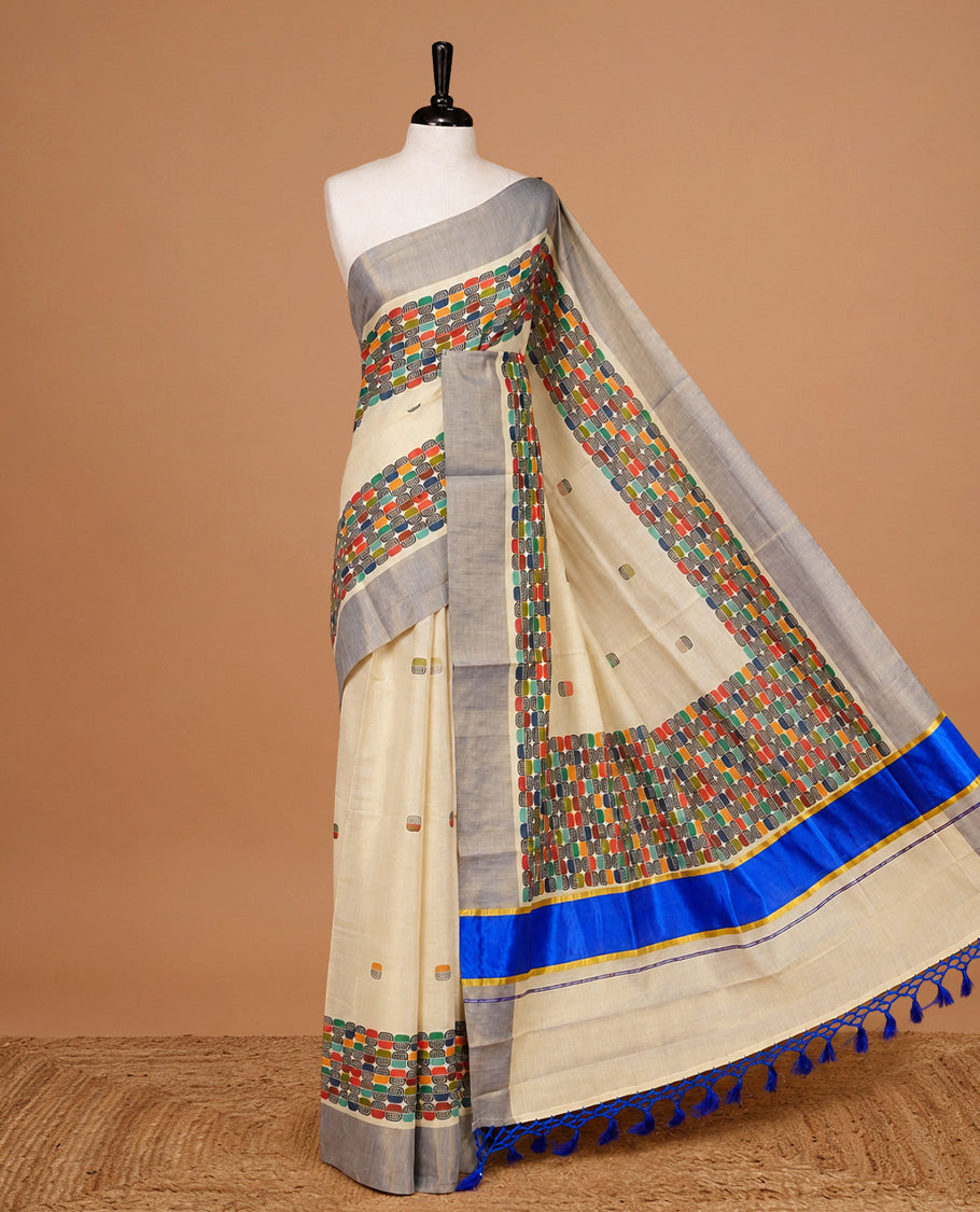Cream colour Tissue kerala saree featuring Classy Multi colour Box pattern on body, Styled by blue & gold zari border and pallu, comes with matching blouse piece.