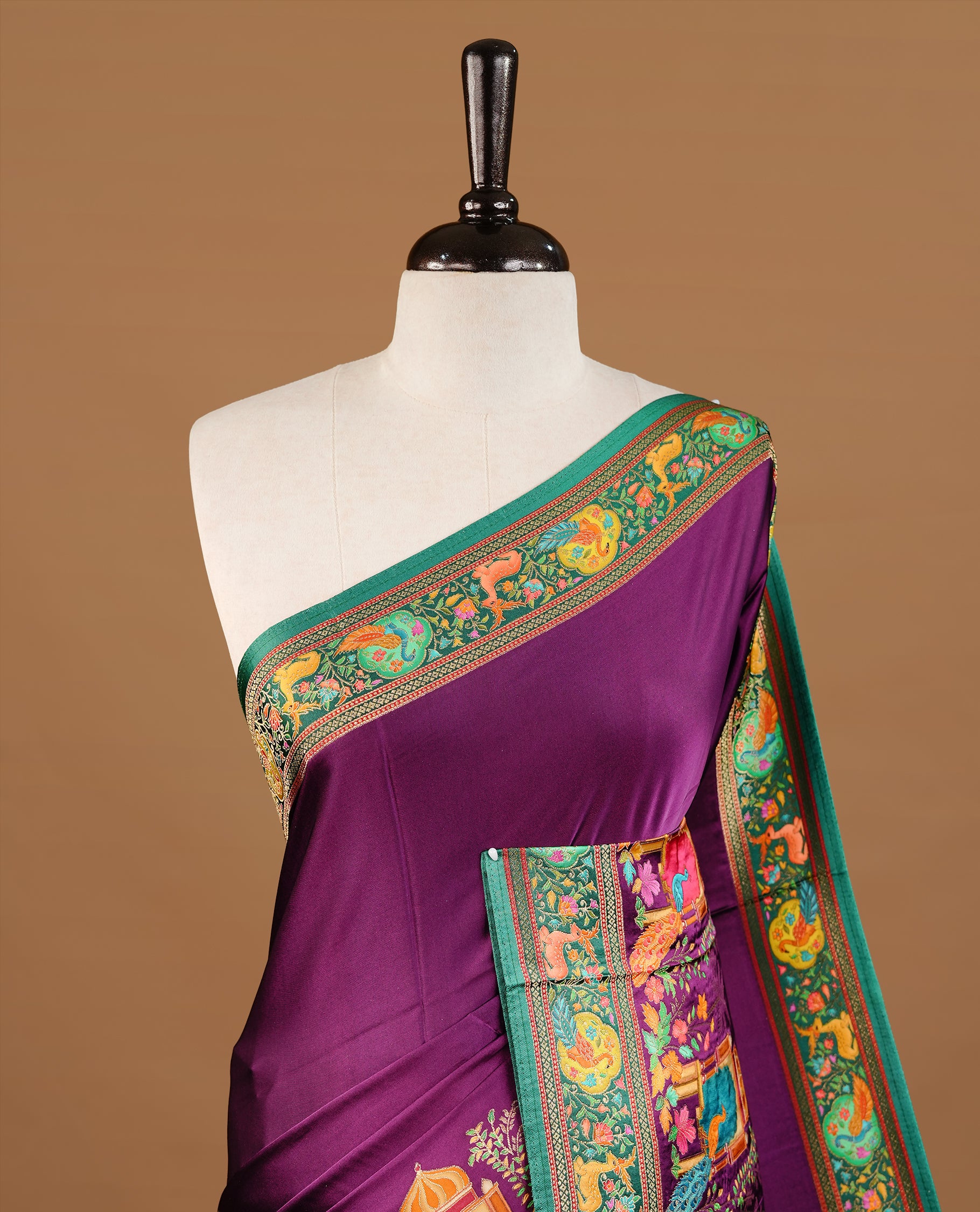 Purple colour Pashmina Saree featuring elegant woven temple and floral motifs, enhanced with a contrast green woven border and a richly detailed traditional pallu, paired with a matching blouse piece.