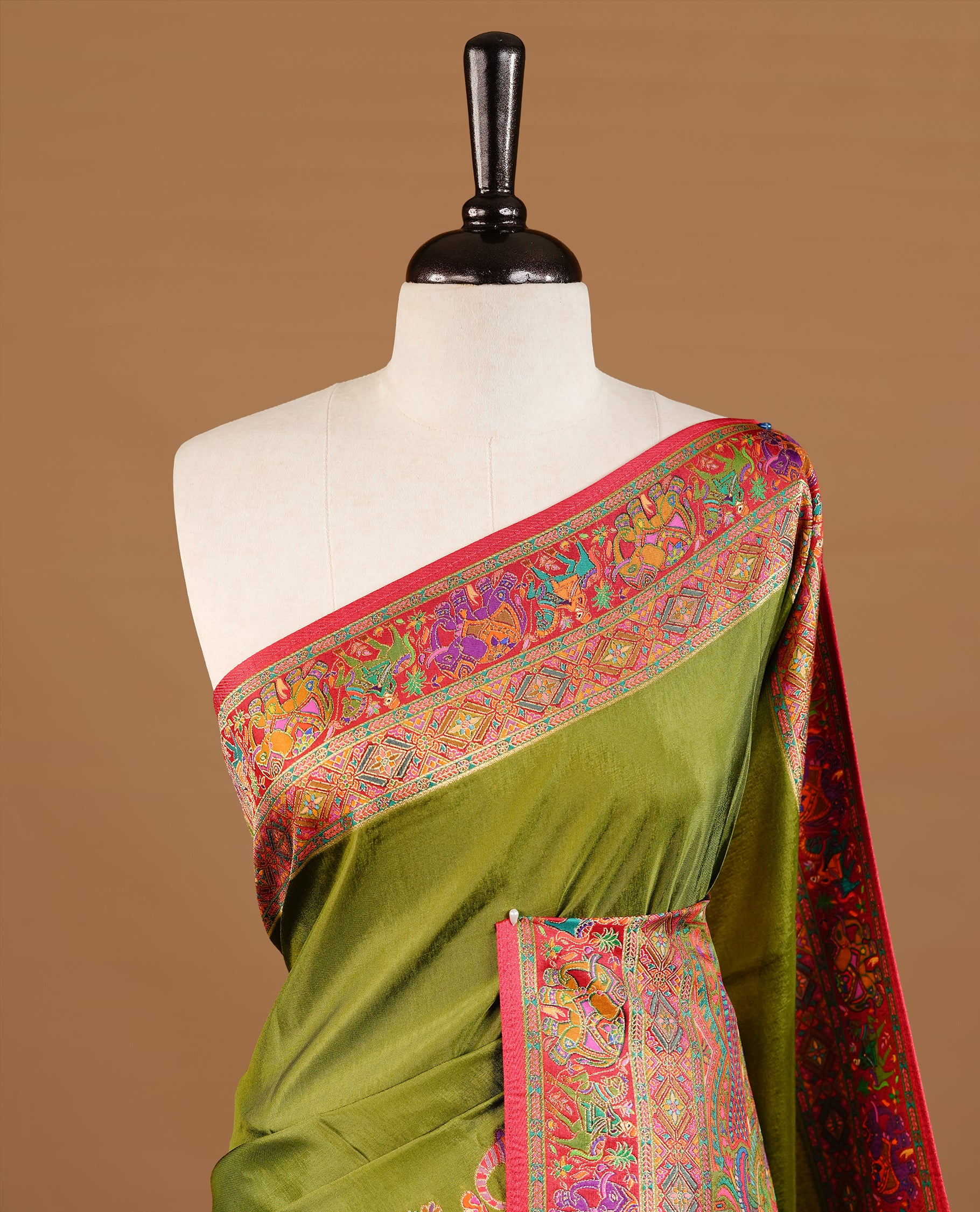 Olive green colour Pashmina Saree featuring Plain body, a contrast multicolour Temple & Paisley woven motifs border with red edging, an ornate paisley woven pallu, paired with a matching blouse.