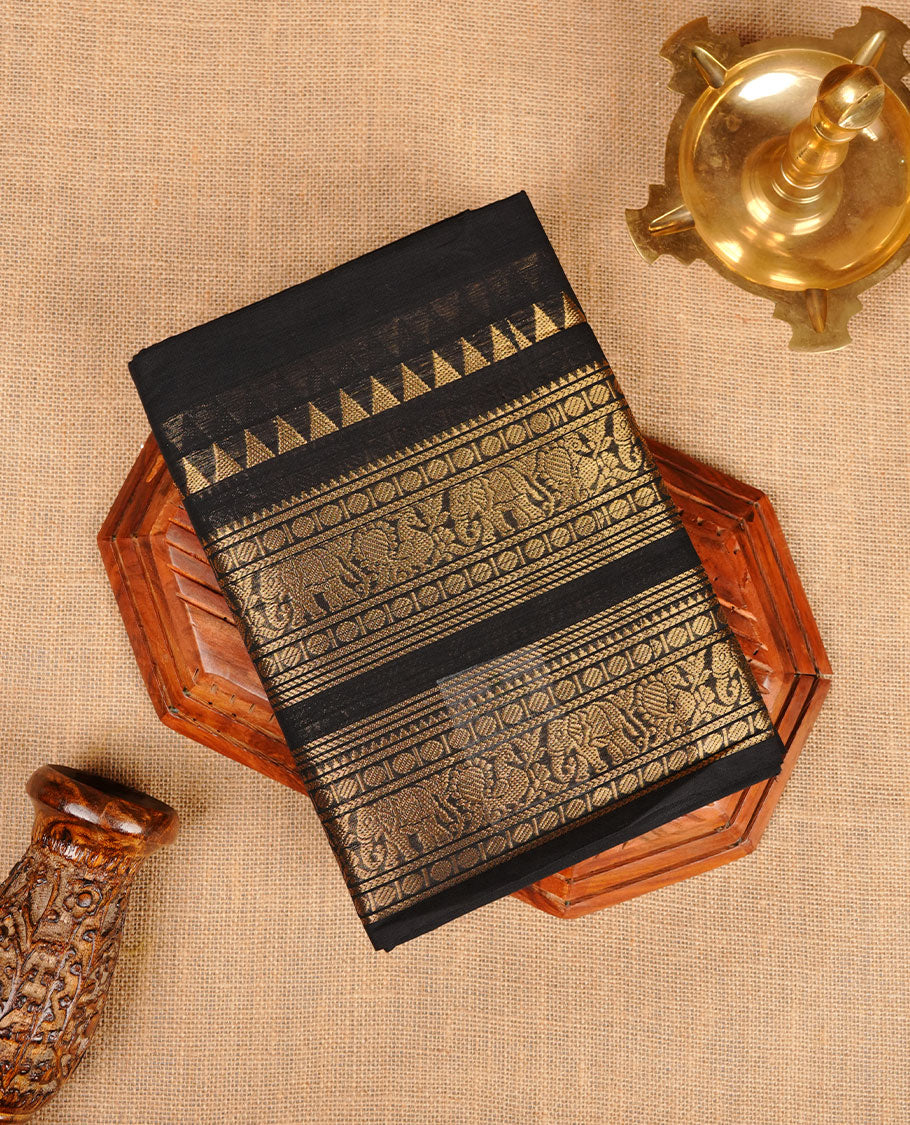 Black colour chettinad cotton saree featuring plain body, self colour with traditional gold zari border paired with matching blouse.