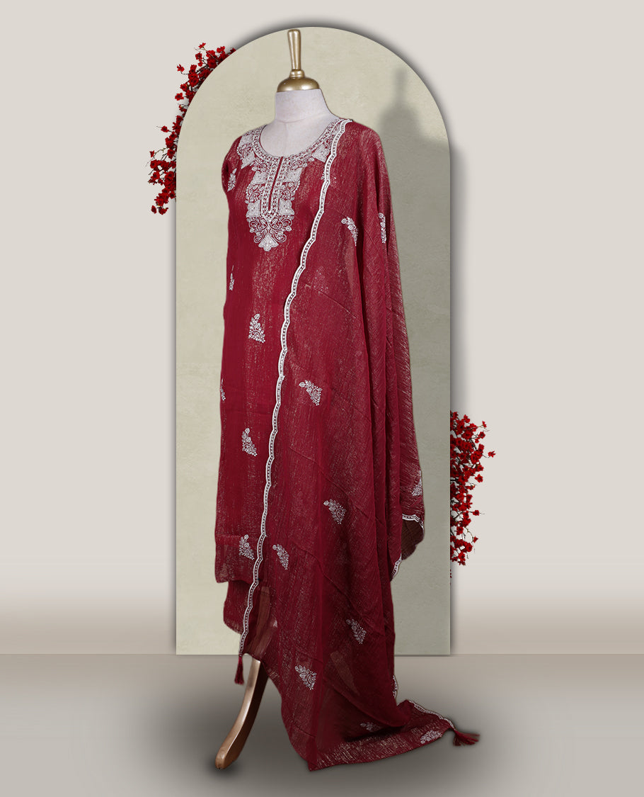 Deep Maroon colour churidar set with a rich sheen, beautifully adorned with golden cut beads work on the neckline and sleeve borders, Paired with a matching dupatta featuring a subtle zari edge, perfect for a regal festive look.