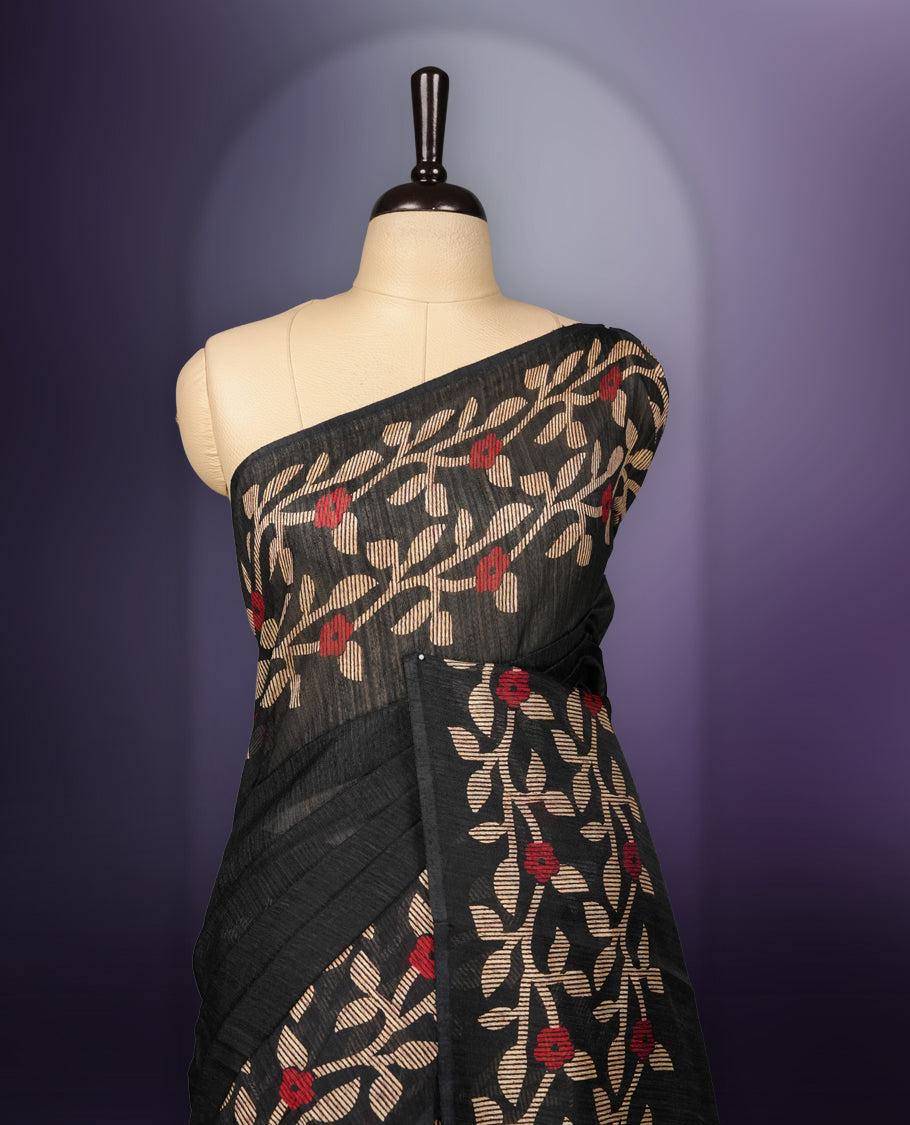 Black colour semi jute silk saree adorned with intricate floral and leaf motifs across the body & The pallu features detailed woven patterns enhancing its charm, paired beautifully with a matching floral printed blouse piece.