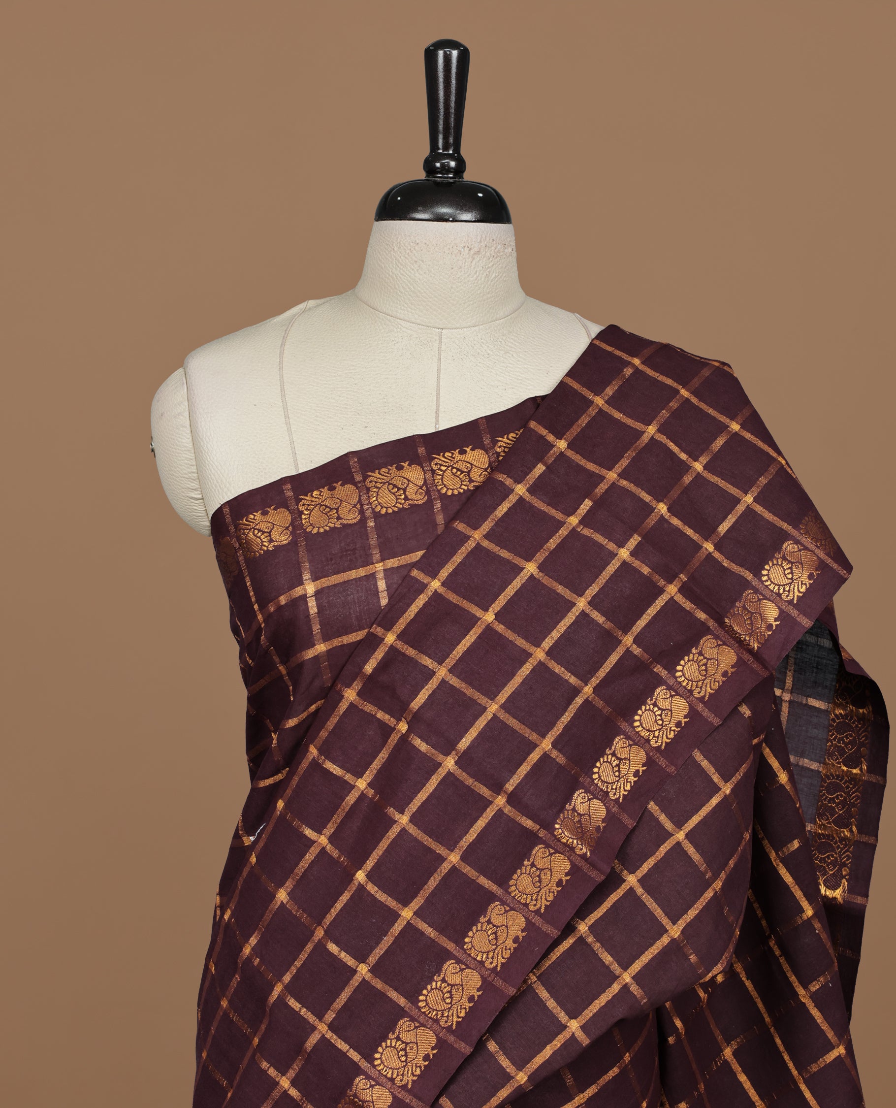 Dark chocolate colour Sungudi cotton saree featuring Gold zari Check pattern on body, Gold zari Peacock design on Self colour border, paired with matching blouse piece.