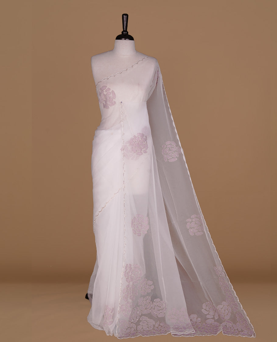 White colour net orange saree featuring pastel purple floral pattern with cut beats on body, highlighting scalp border, paired with matching blouse piece.