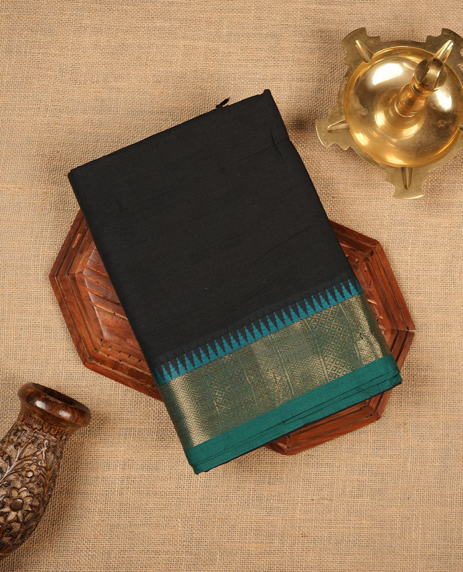 Black colour chettinad cotton saree featuring Elegant plain body highlighting contrast green colour colour with gold zari traditional border, pallu and paired with matching blouse piece.