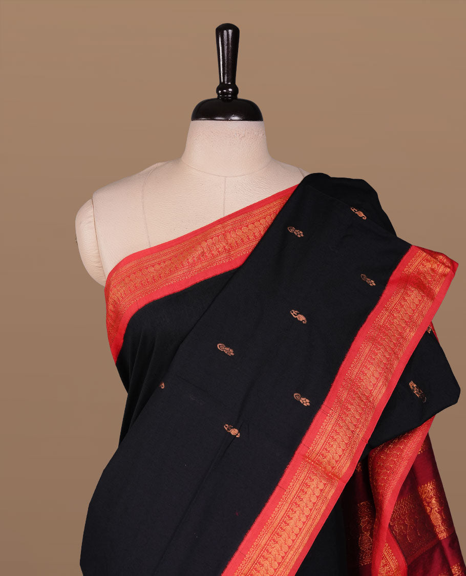 Black colour kalyani cotton saree featuring antique zari motifs on body, complemented by red colour with Antique zari border, paired with matching blouse piece.