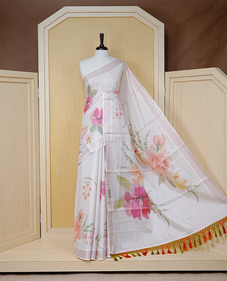 Cream Colour Tissue Kerala Saree Featuring A Digital Floral Printed Body & Pallu , Beautifully Enhanced With A Classic Rose Gold Zari Border And Orange & Olive Green Tassels, Paired With A Matching Blouse Piece.