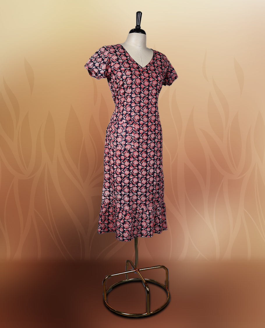 Black colour nightwear adorned with soft pink floral prints, featuring a V neckline, short sleeves, and a flared ruffle hem, A stylish and comfortable choice for daily wear, brunches, or casual outings.