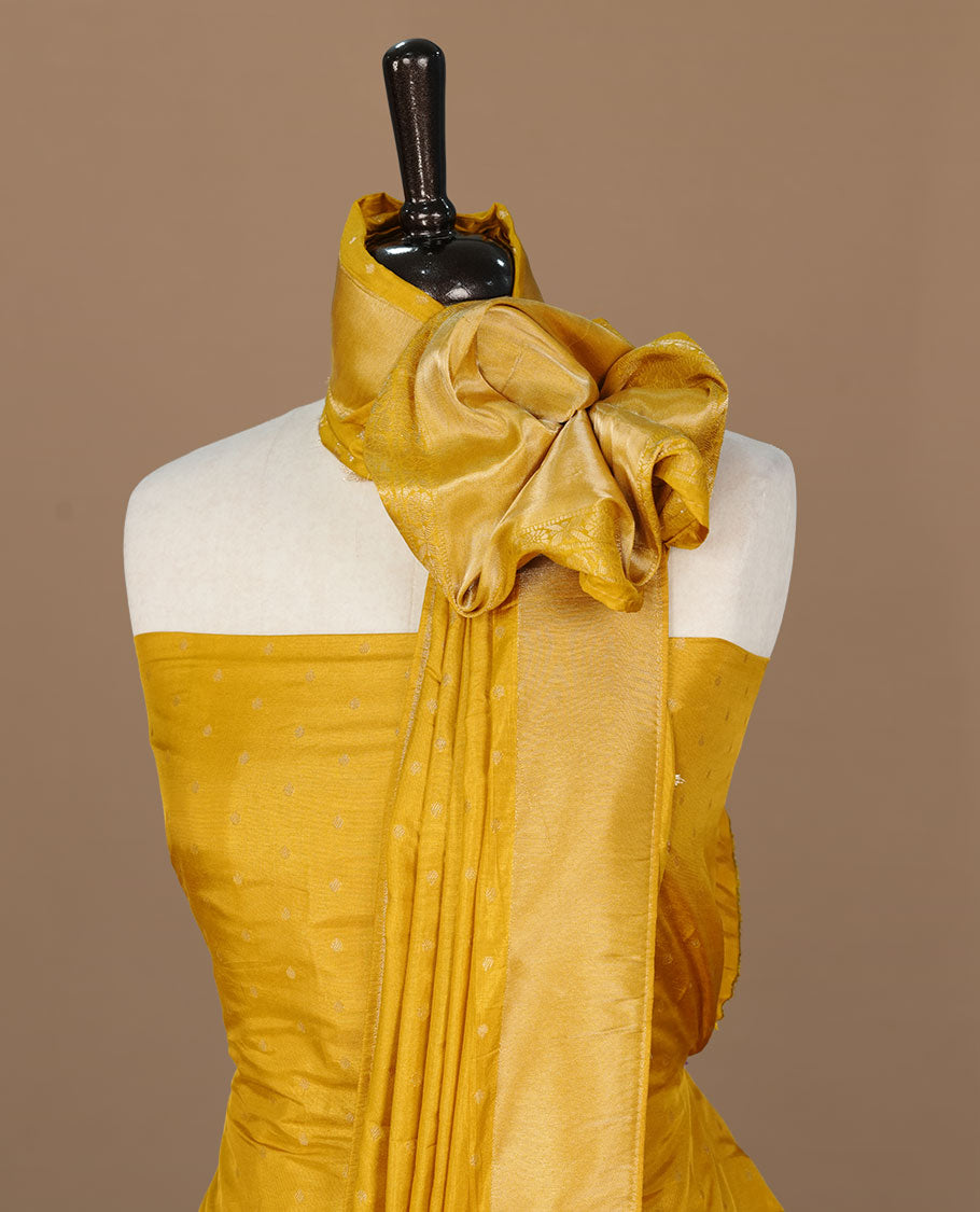 Yellow colour churidar material featuring Gold zari buttas on body, paired with matching bottom and dupatta.
