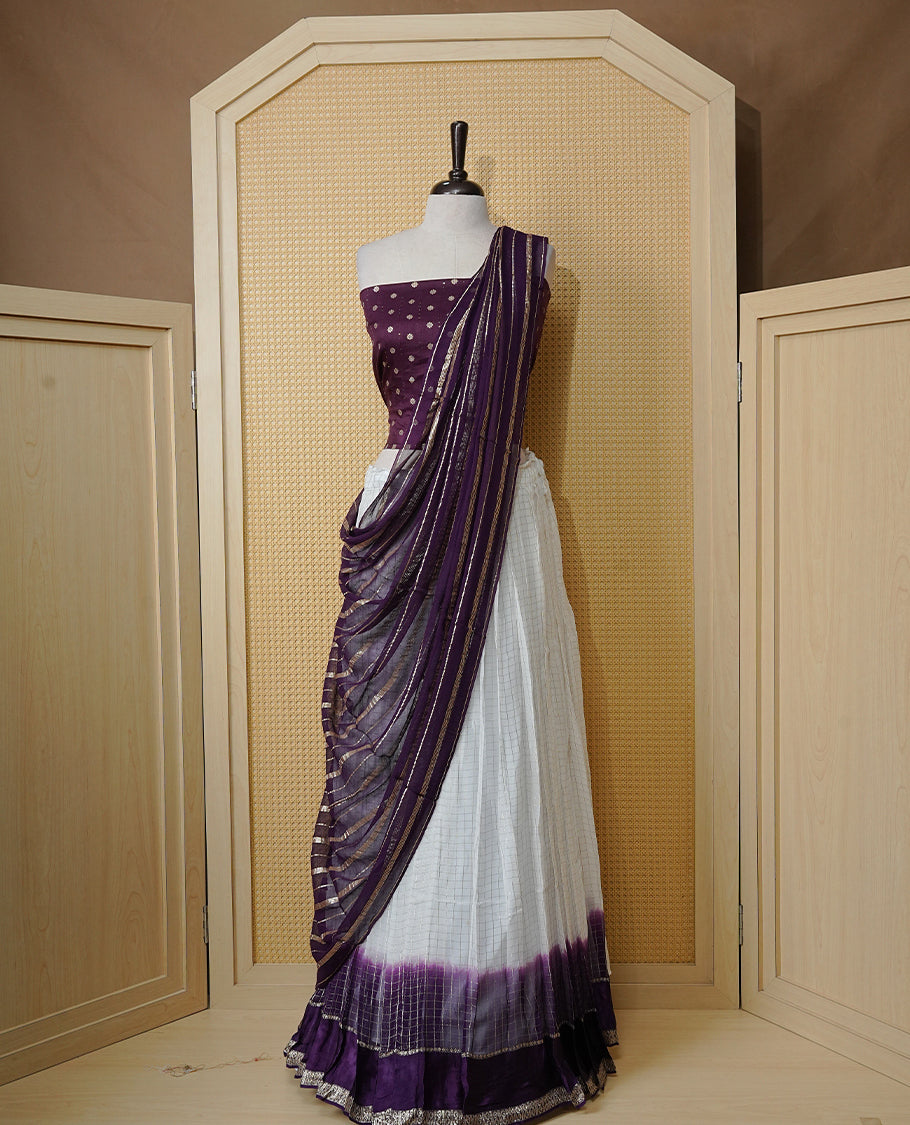Off white colour Semi stitched dhavani set featuring Gold zari check pattern with contrast Violet border skirt, paired with matching blouse & dupatta.