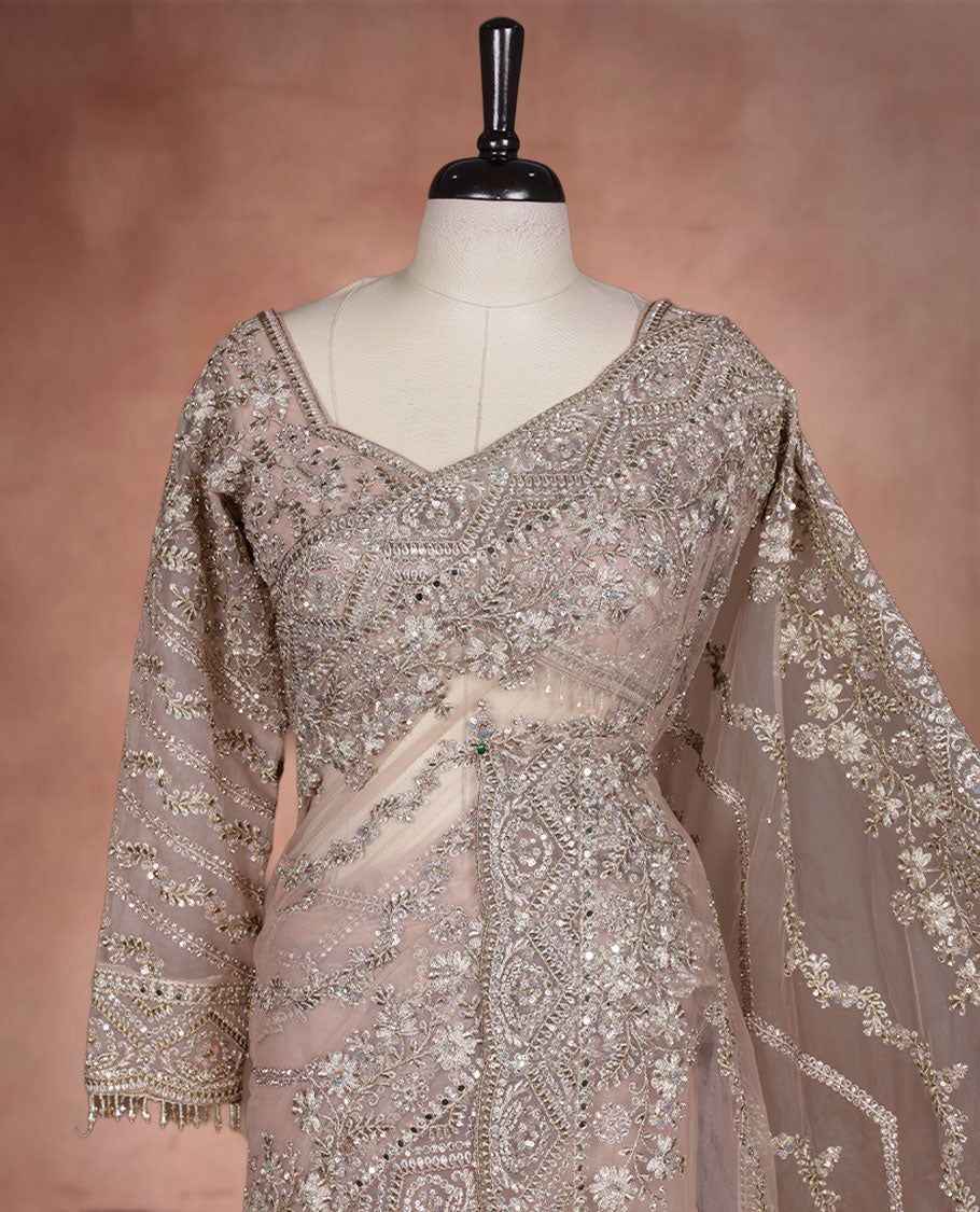 Beige Colour net designer Wedding saree featuring all over floral embroidery with sequin detailing and an ornate scalloped border, finished with a matching embellished blouse.