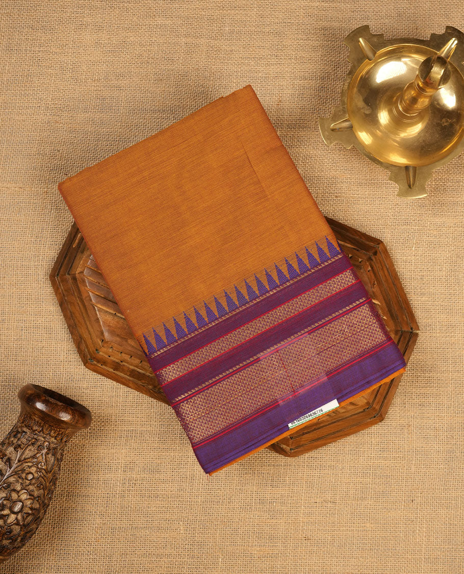 Brown colour chettinad cotton saree featuring elegant plain body highlighting contrast indigo colour with gold zari traditional border, pallu and paired with matching blouse piece.