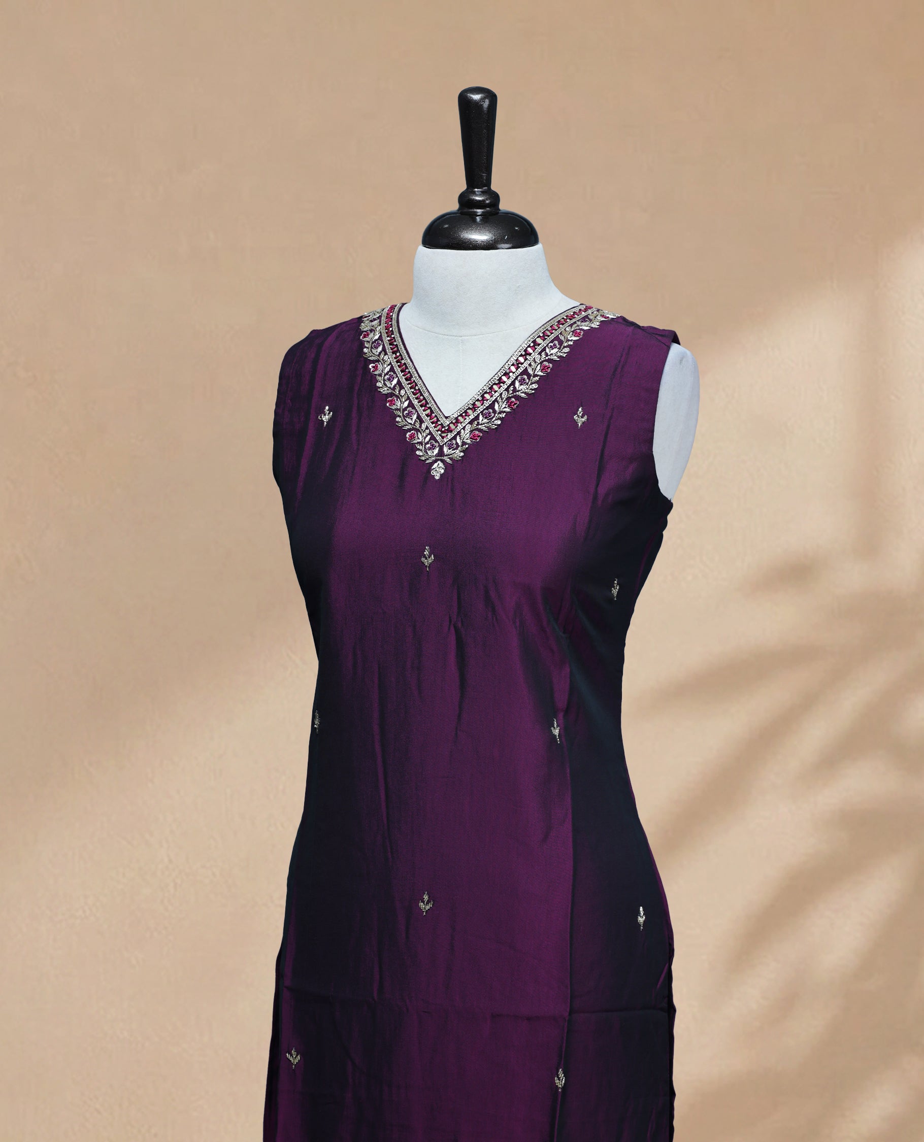 Purple Colour Kurti featuring beadwork across the body, a V-shaped neckline adorned with bead and mirror work and a sleeveless design.