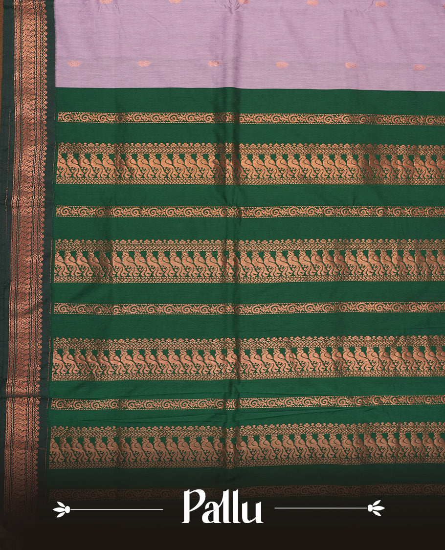 Lavender colour Kalyani Cotton saree with delicate woven zari motifs all over, paired with a contrasting deep green border and pallu intricately woven with rich copper peacock zari & Comes with a matching blouse piece.