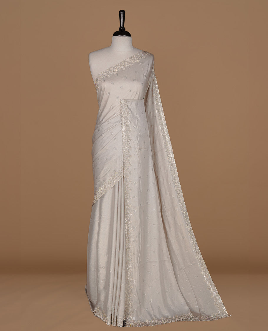 Off white colour organza designer saree featuring Gold stone motifs on body, highlighting light weight stone worked border, paired with matching blouse piece.