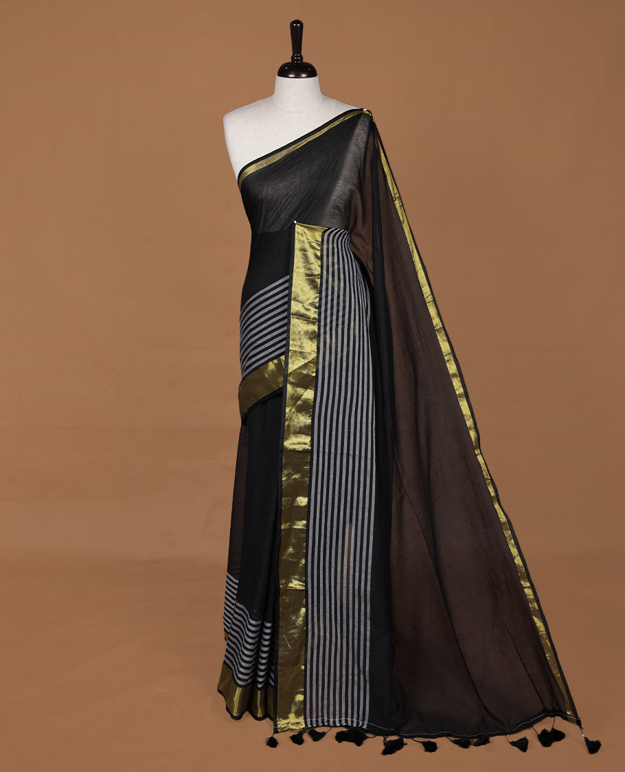 Black colour saree with Gold tones, featuring a minimal plain design on the body, without blouse piece.
