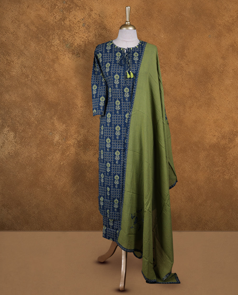 Crystal teal colour churidar set featuring round neckline, three‑fourth sleeves, and all‑over ethnic floral print on body, paired with a contrasting green solid dupatta with printed edging.