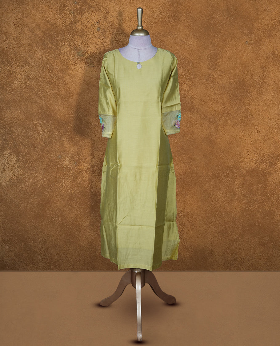Pistachio green solid kurti featuring a round neckline with a subtle keyhole detail, a straight calf-length silhouette, and three-quarter sleeves highlighted with delicate floral embroidery.