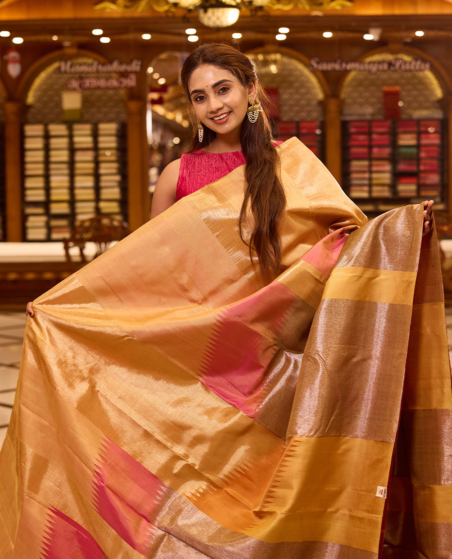 Elegant golden beige colour Kancheepuram silk saree featuring subtle woven geometric highlights with soft pink accents, beautifully paired with a rich contrast pallu and styled with a vibrant blouse